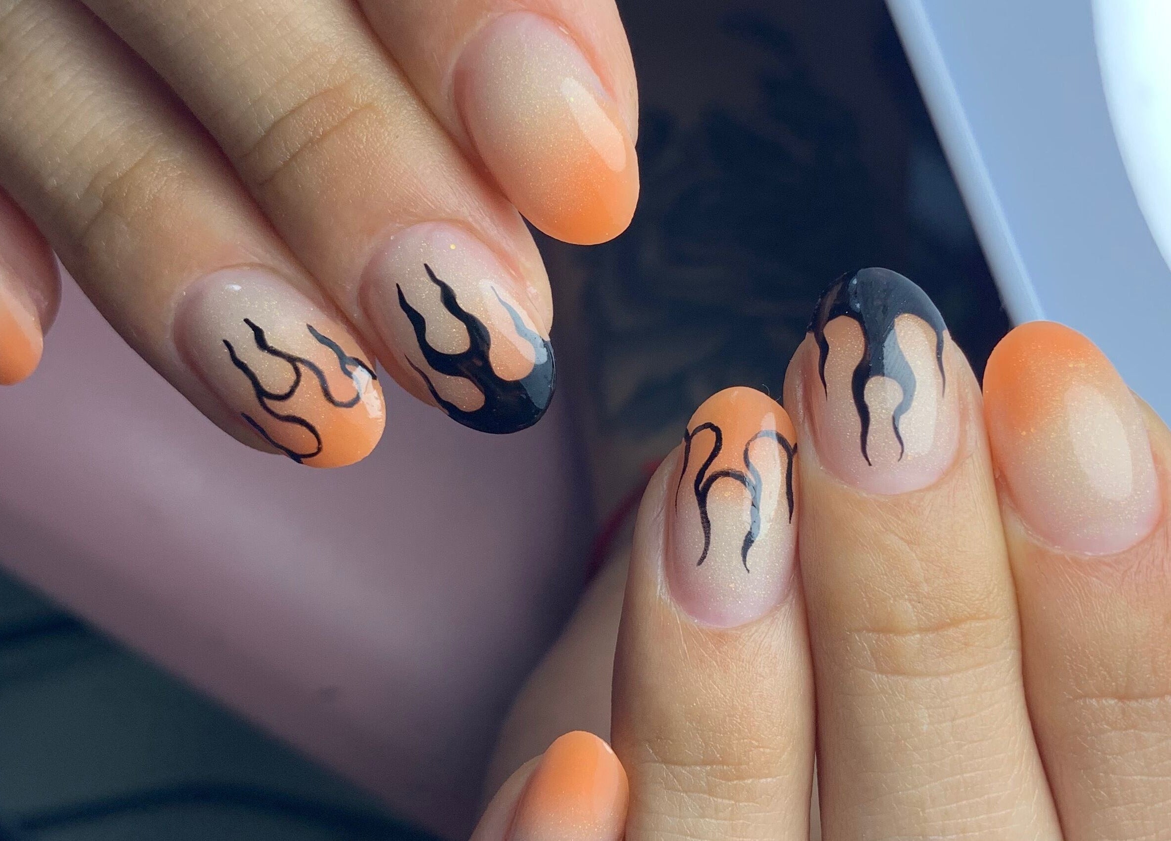 Fiery black and orange nail art at Primero las uñas, La Falda, Córdoba, AR.