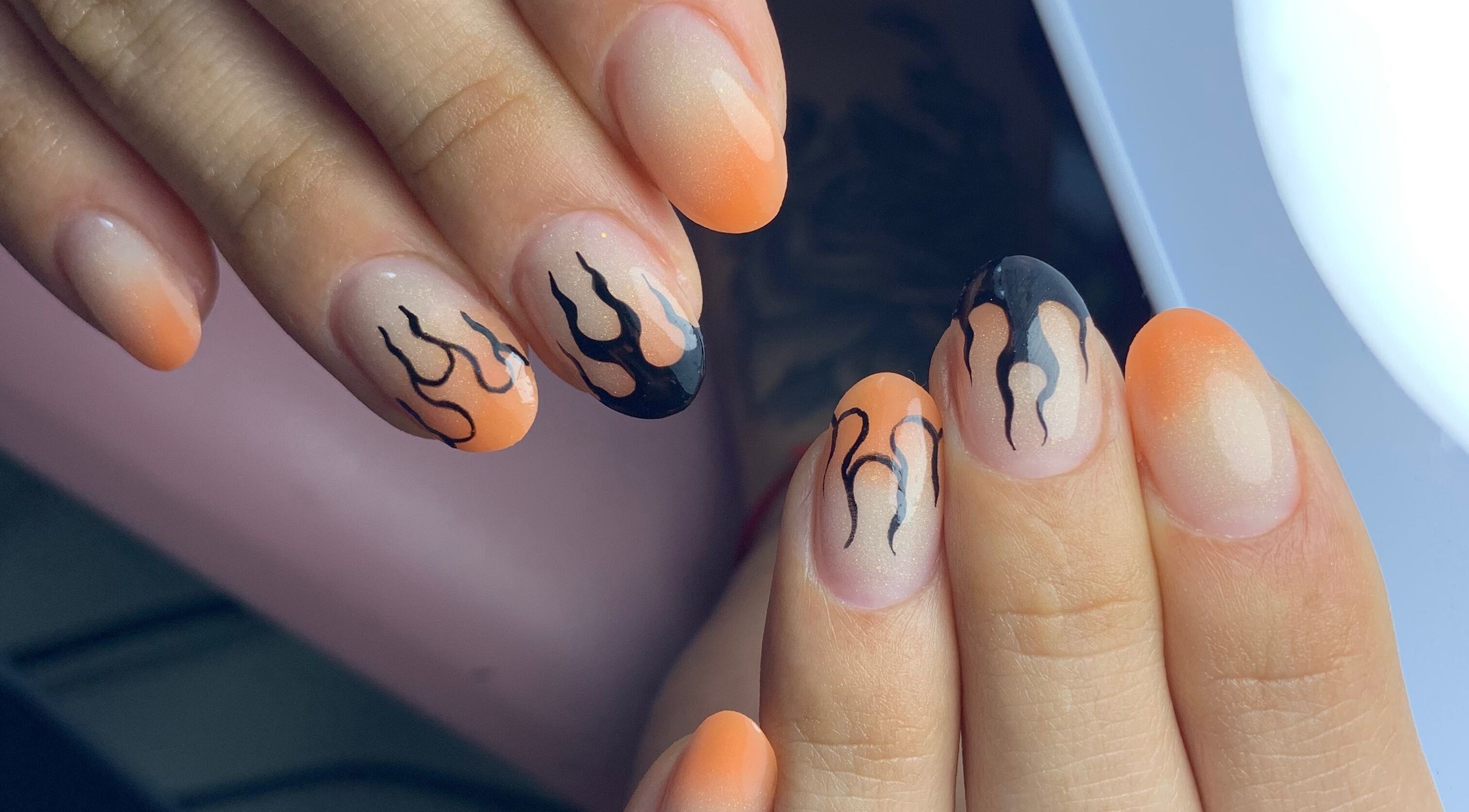 Fiery black and orange nail art at Primero las uñas, La Falda, Córdoba, AR.
