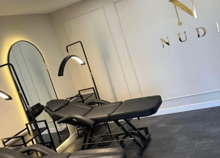 Modern treatment chairs at The Nude Method, Glasgow, Scotland, GB, with ambient lighting and stylish decor.