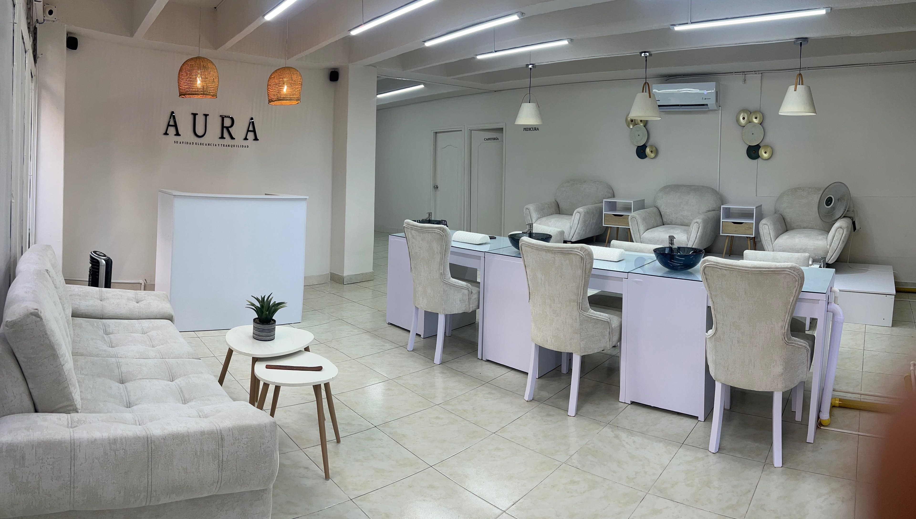 Recepción moderna de Aura Nails Spa en Caldas, Caldas, CO con muebles blancos elegantes.