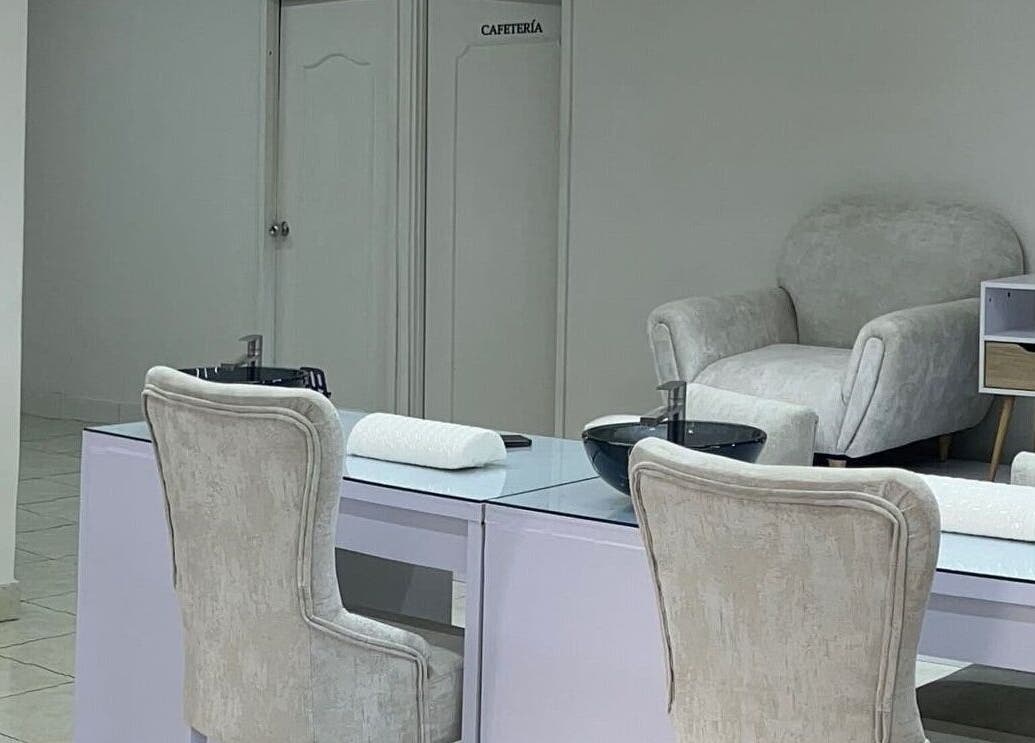 Sala de tratamiento en Aura Nails Spa, Caldas, Caldas, CO, con sillas cómodas y mesas de manicura.