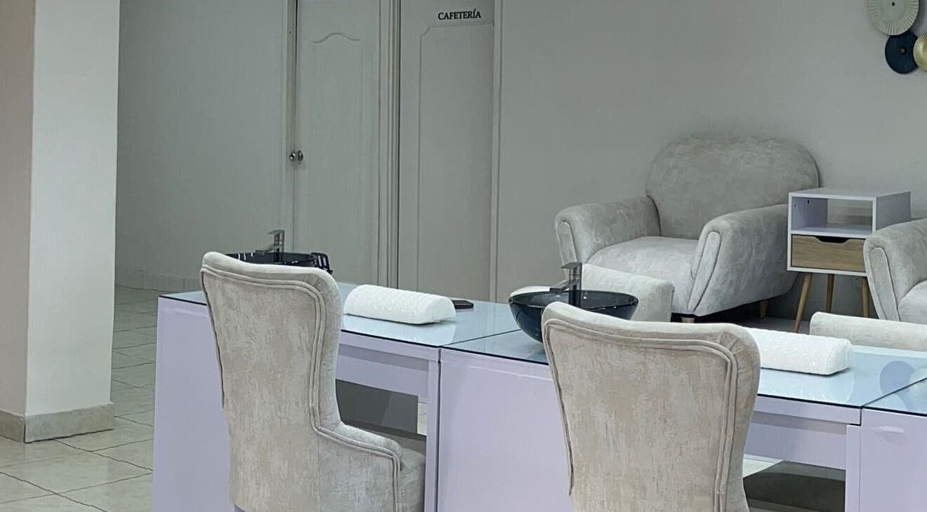 Sala de tratamiento en Aura Nails Spa, Caldas, Caldas, CO, con sillas cómodas y mesas de manicura.
