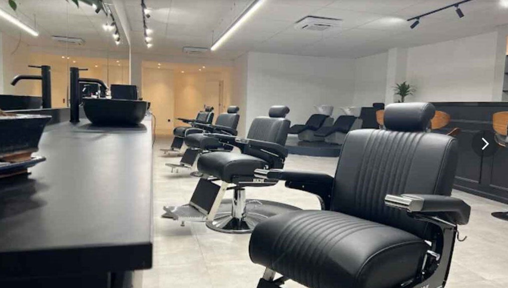 Moderne kappersstoelen bij Bock-Mencare, Geleen, Limburg, NL, bevorderen een verfijnde welzijnservaring.