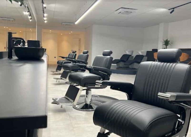 Moderne kappersstoelen bij Bock-Mencare, Geleen, Limburg, NL, bevorderen een verfijnde welzijnservaring.