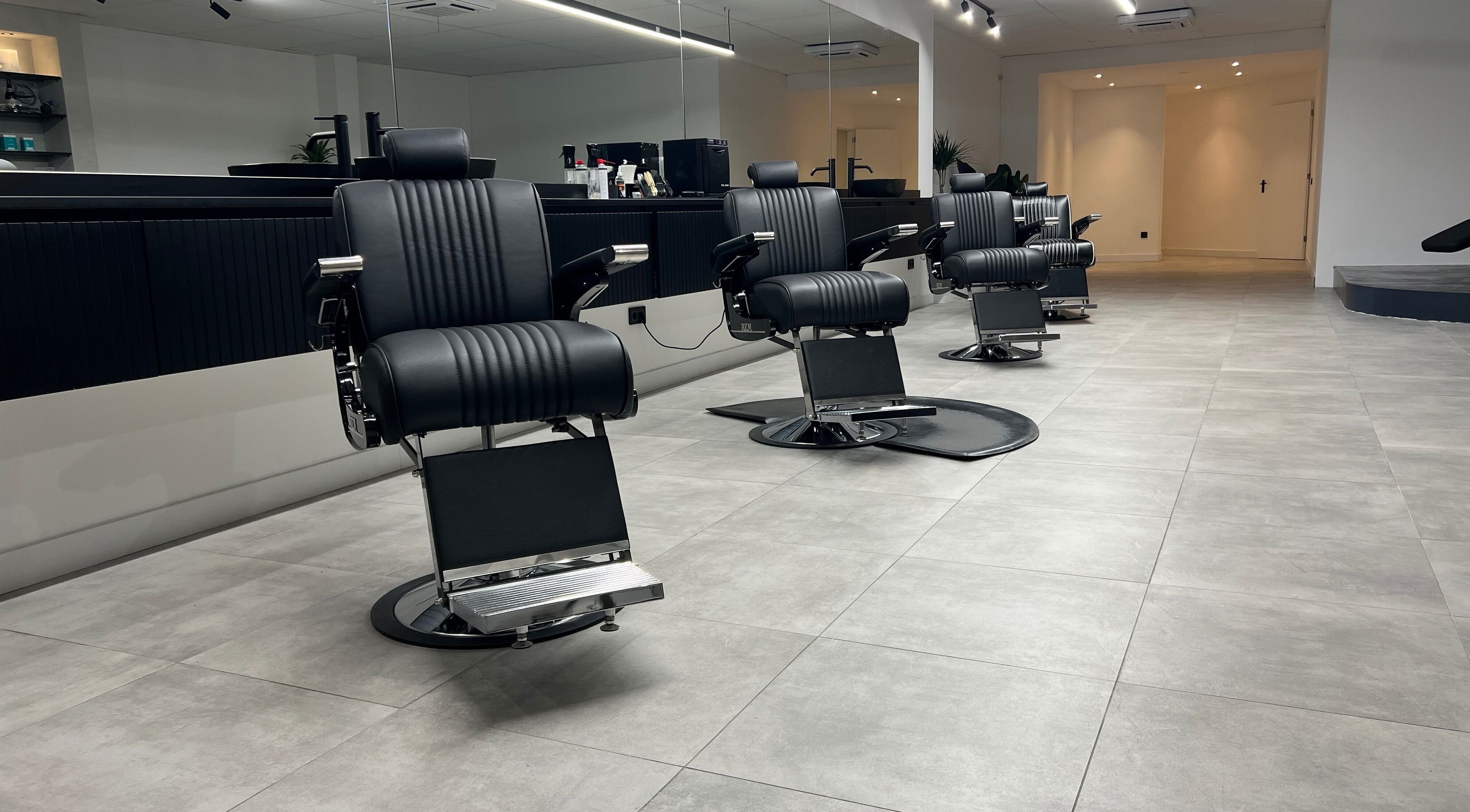 Moderne kappersstoelen bij Bock-Mencare, Geleen, Limburg, NL, in een stijlvolle salonsetting.