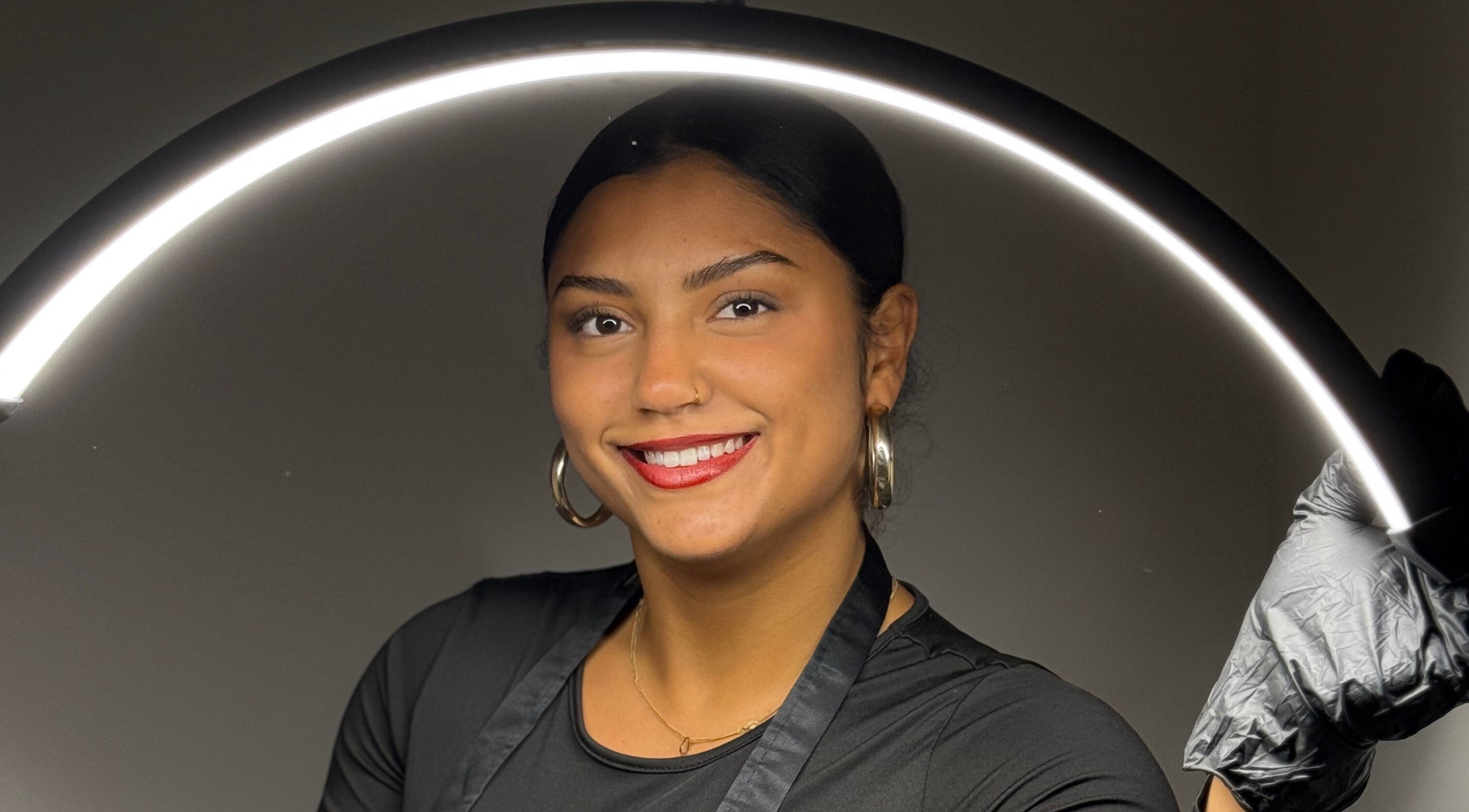 Esthéticienne souriante chez Mc Beauty Brow, Saint-brieuc, Bretagne, FR, sous une lumière circulaire.