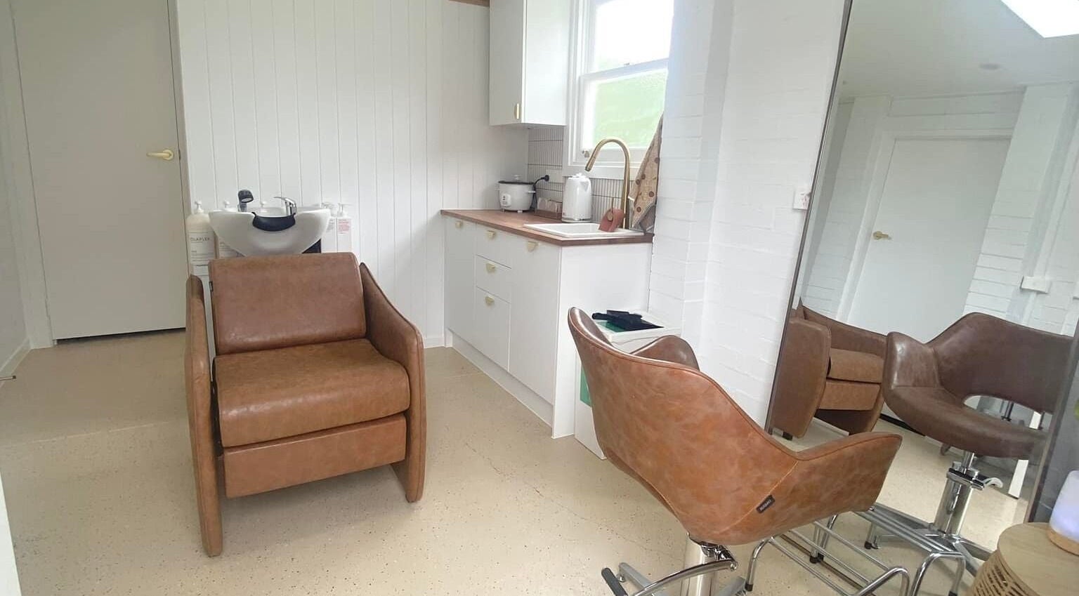 Elegant salon chair and mirror at Prosper Studio, Belmont, Victoria, AU featuring modern decor.