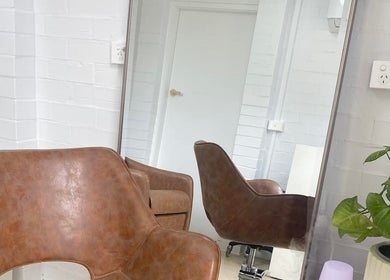 Stylish interior of Prosper Studio in Belmont, Victoria, AU, featuring a leather chair and mirror reflection.