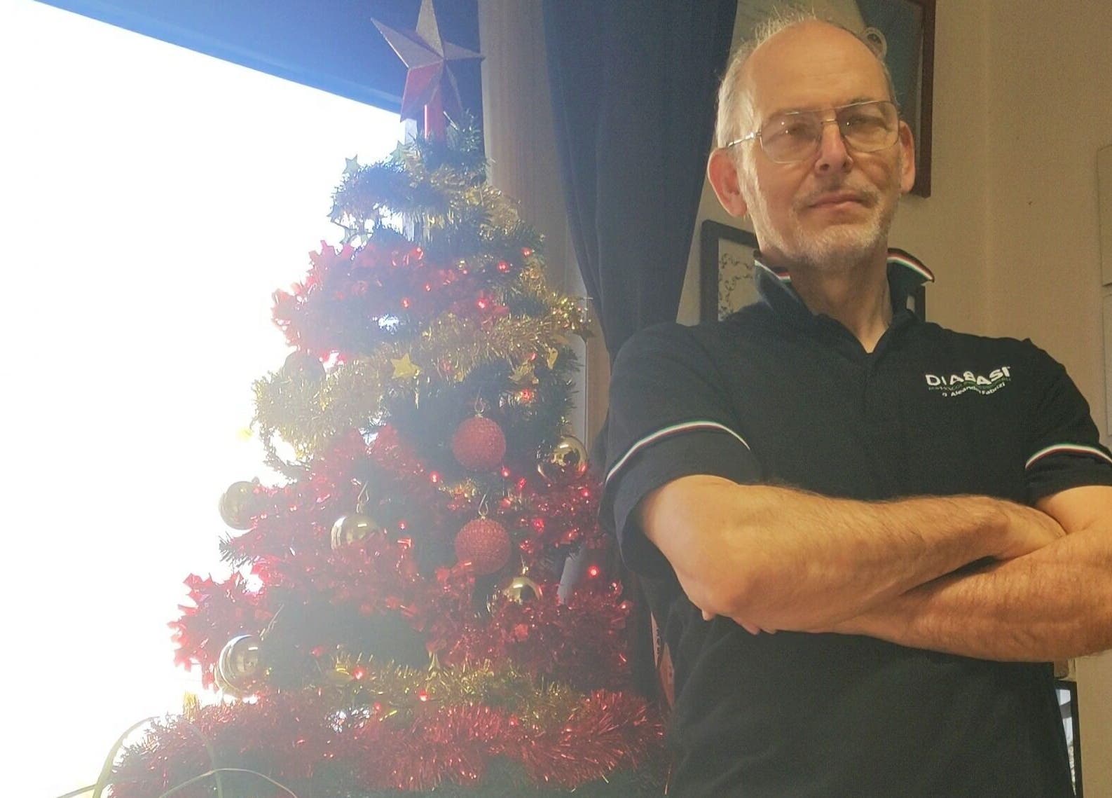 Professionista DIABASI MASSAGGI di Aleandro Fabrizi accanto ad albero di Natale, Firenze, Toscana, IT.