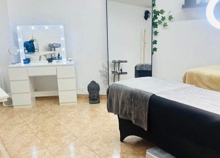 Sala de belleza en Paolys Hernández, Barcelona, Catalunya, ES, con tocador iluminado y mesa de masaje.