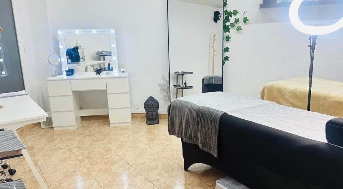 Sala de belleza en Paolys Hernández, Barcelona, Catalunya, ES, con tocador iluminado y mesa de masaje.