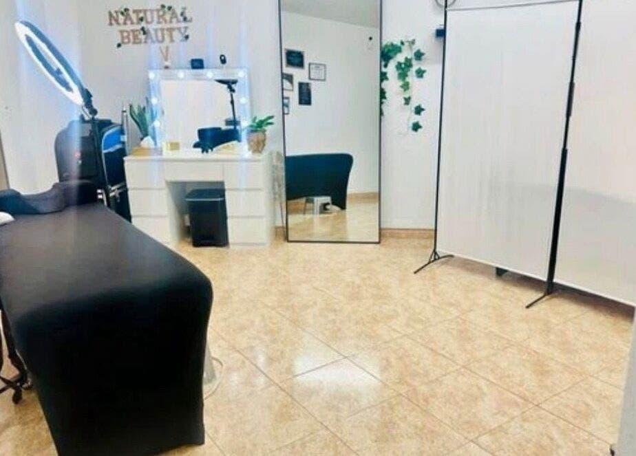 Interior del spa Paolys Hernández en Barcelona, Catalunya, ES, mostrando camilla y tocador elegante.