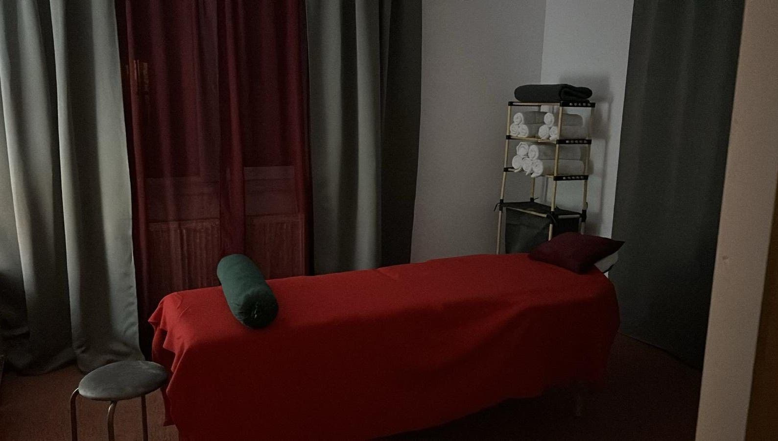 Relaxing massage room at QuantumEvo, Brașov, Județul Brașov, RO, featuring a red sheeted massage table.