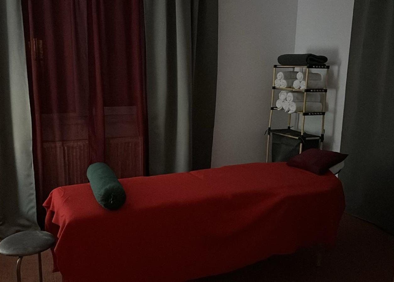 Relaxing massage room at QuantumEvo, Brașov, Județul Brașov, RO, featuring a red sheeted massage table.