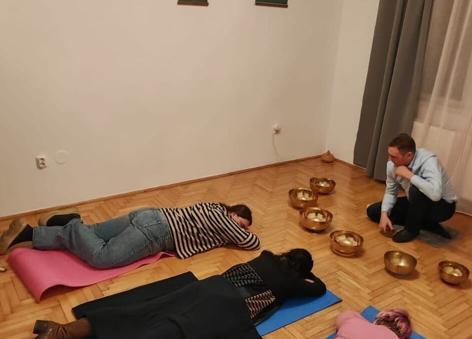 Sound therapy at QuantumEvo, Brașov, Județul Brașov, RO with participants relaxing on mats.