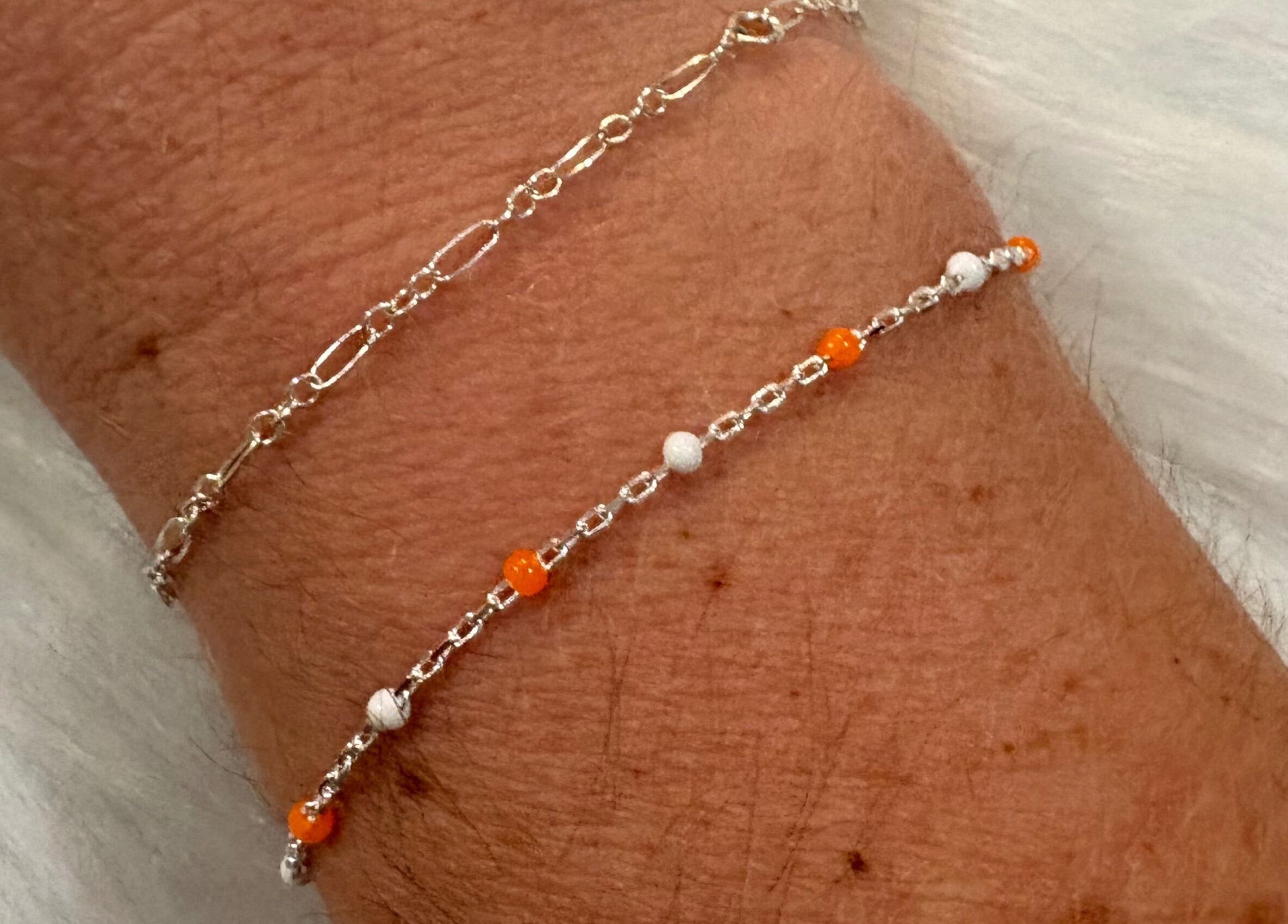 Layered & Linked bracelets showcase intricate silver and orange design in Madisonville, Tennessee, US.