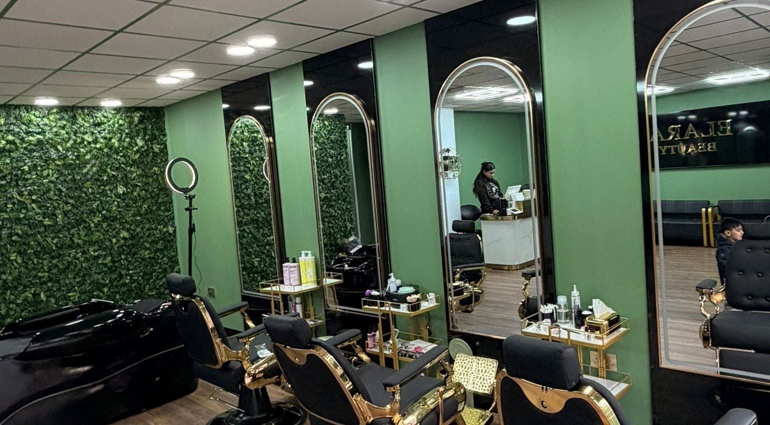 Modern salon interior at ELARA BEAUTY, Tranent, Scotland, GB, with stylish chairs and green decor.