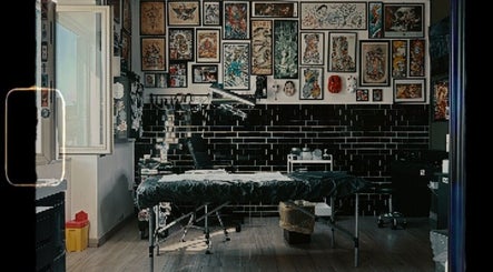 Interno di No Fear Tattoo Shop a Pozzuoli, Campania, IT, con opere d'arte e attrezzature professionali.