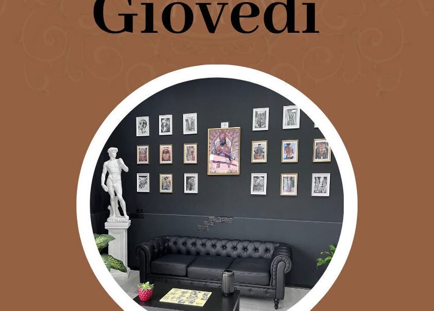 Salone elegante di Got Ink Tattoo a Marzanello, Campania, IT con divano nero e parete decorata.