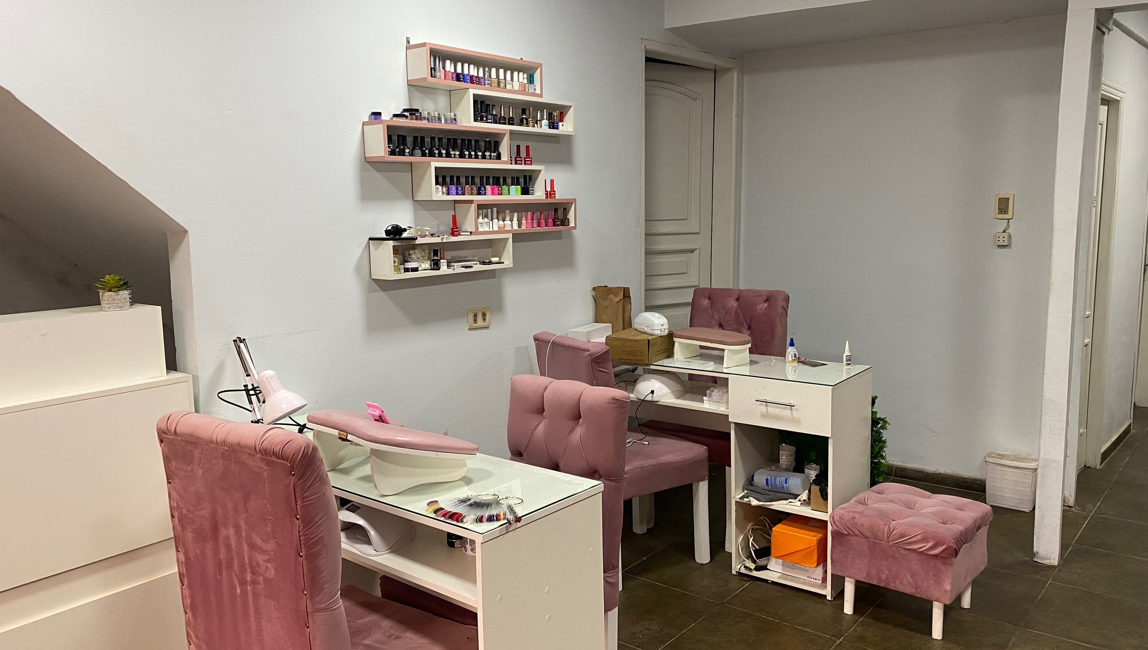 Chic nail salon setup at Sibaris, Luque, Central, PY featuring plush pink chairs and organized nail polish racks.