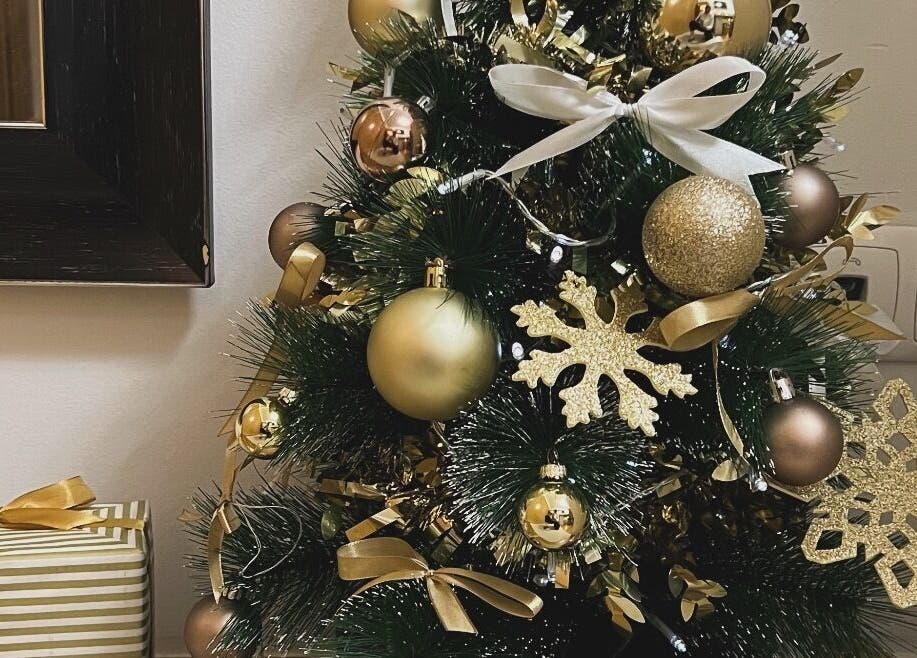 Árvore de Natal elegante no Aura Private Nail Suite, Camarate, Lisboa, PT, decorada com ornamentos dourados.