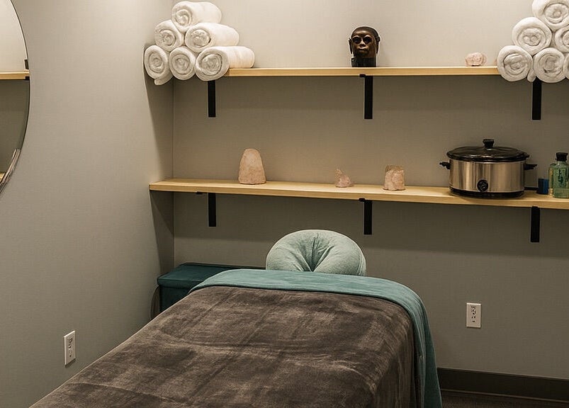 Cozy massage room at Aura Eleven Massage, Stafford Township, New Jersey with neatly arranged towels and tranquil decor.