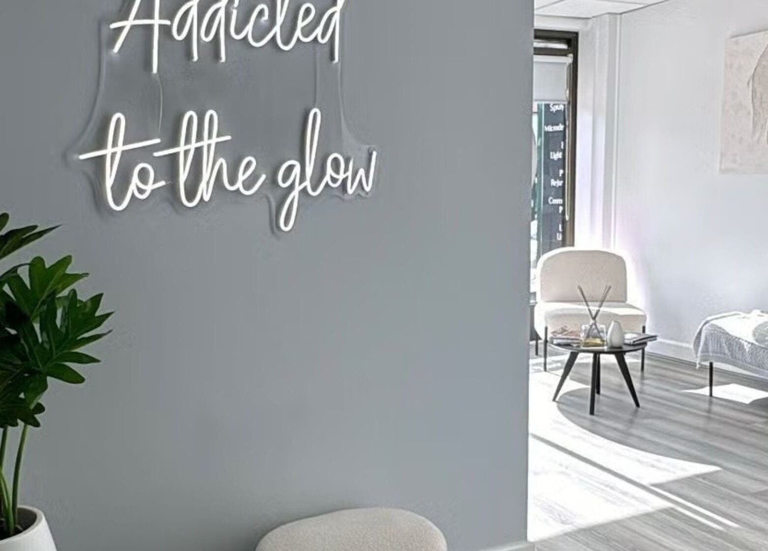 Bright and serene interior of Lumi Whitening in Melbourne, Victoria, AU featuring a 'Addicted to the glow' neon sign.