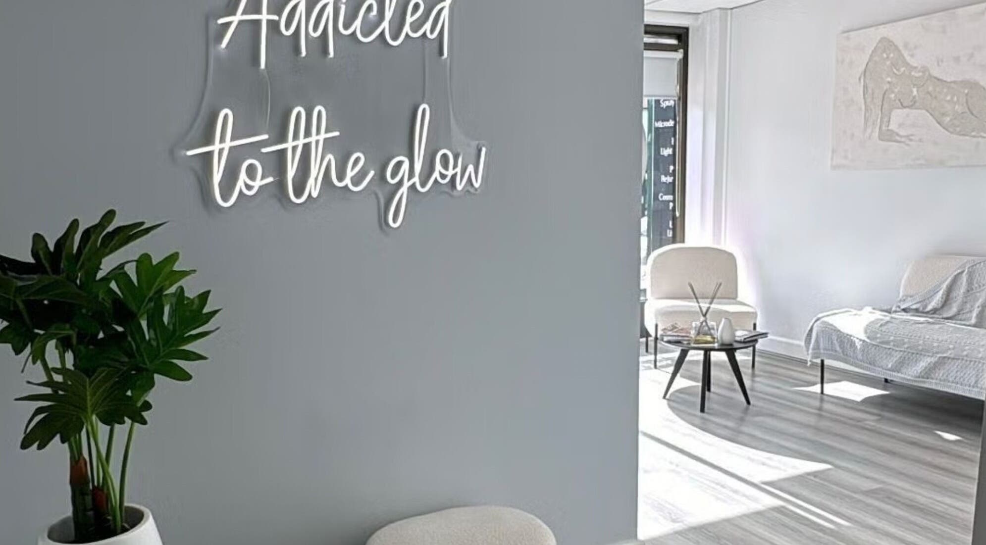 Bright and serene interior of Lumi Whitening in Melbourne, Victoria, AU featuring a 'Addicted to the glow' neon sign.
