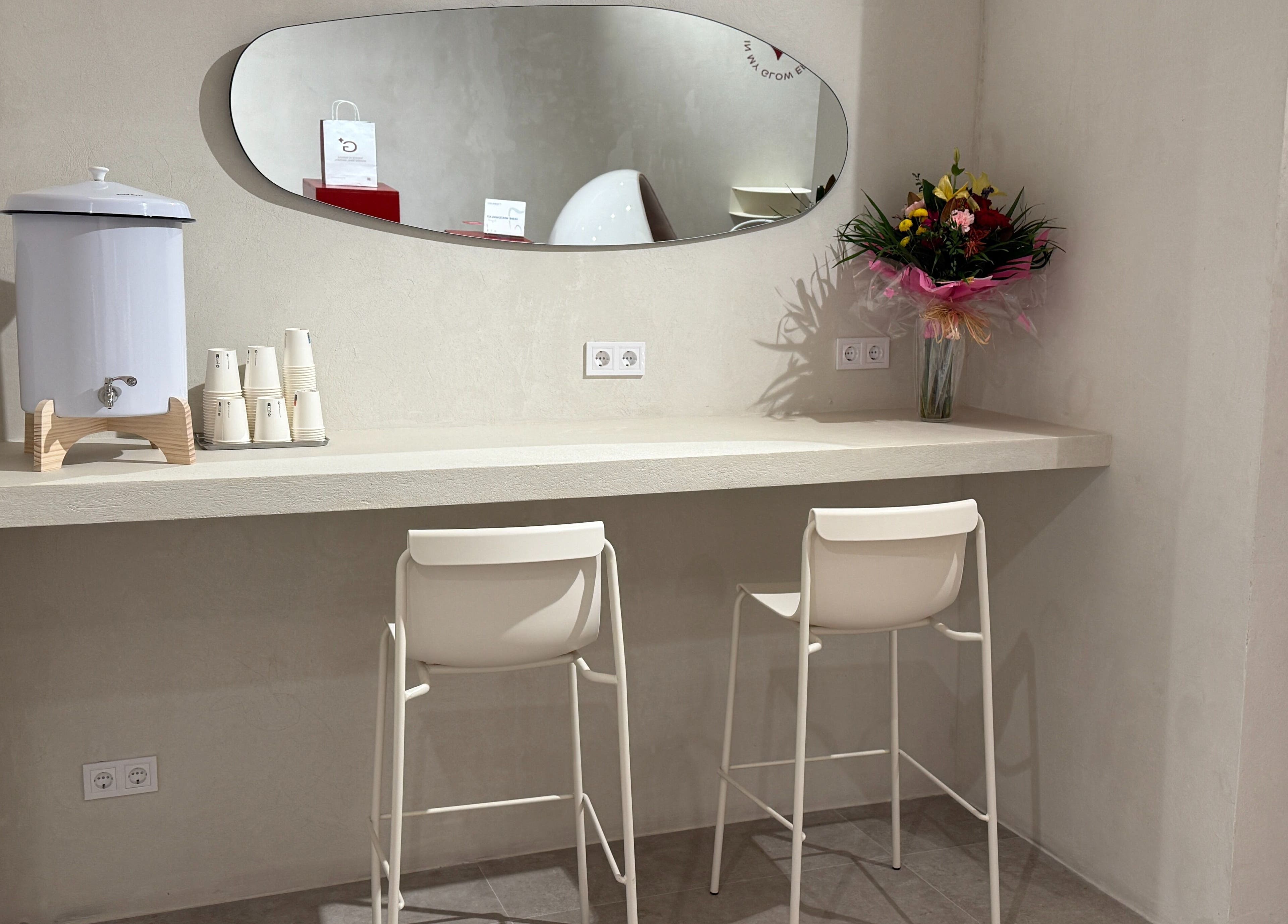 Elegante rincón en Glow White, Barcelona, Catalunya, ES, con florero colorido y sillas modernas.