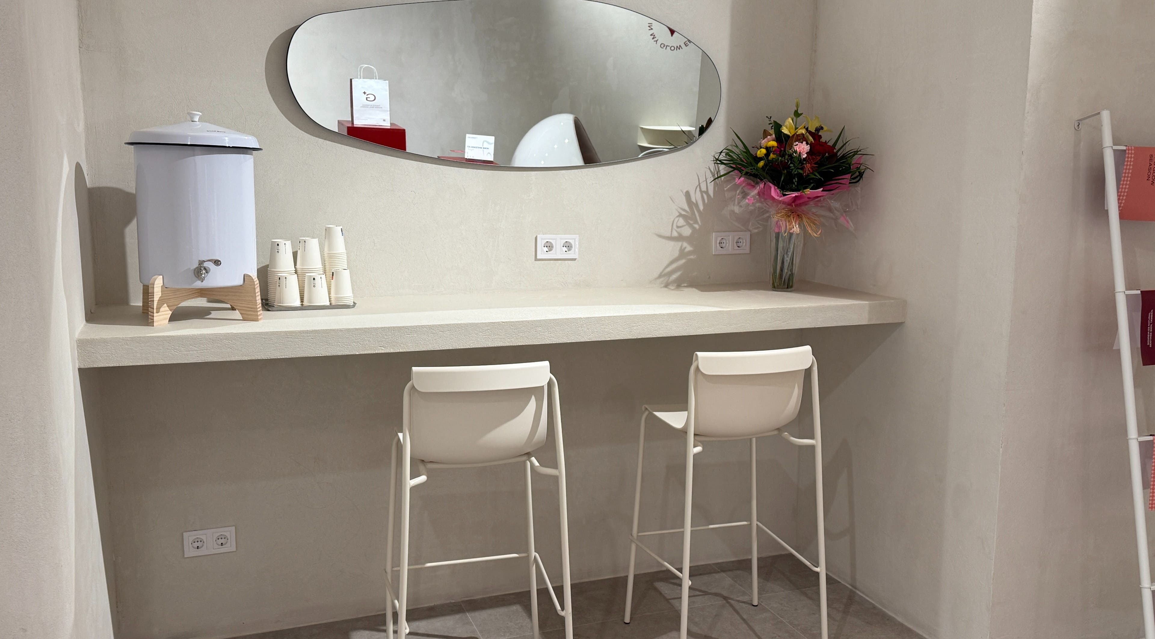 Elegante rincón en Glow White, Barcelona, Catalunya, ES, con florero colorido y sillas modernas.