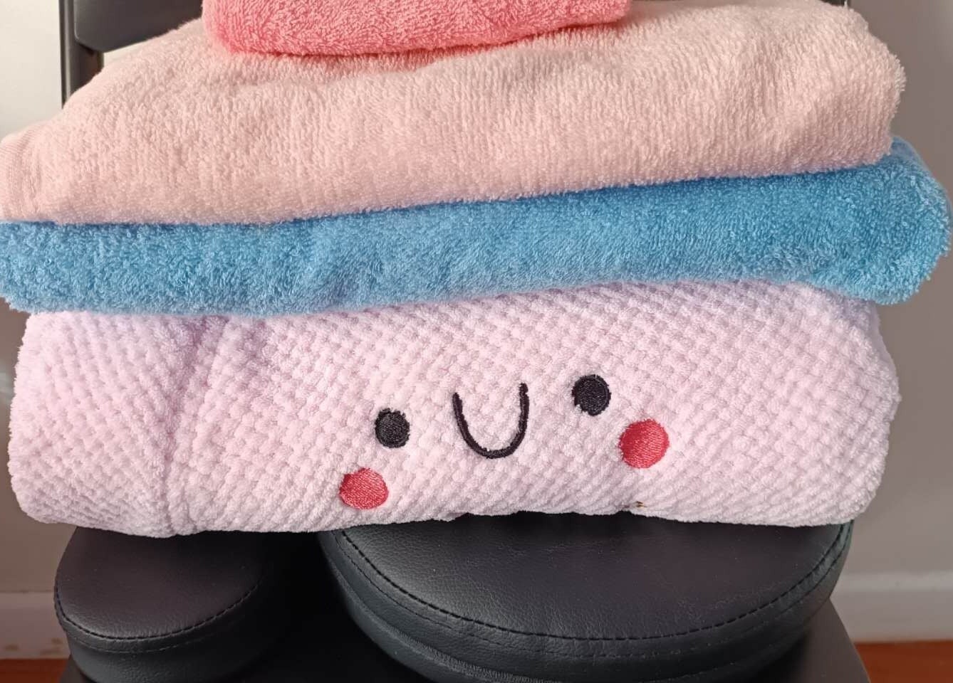 Stack of colorful towels at Harmony River - Home Studio (Sandringham), Auckland, NZ, creating a cozy vibe.