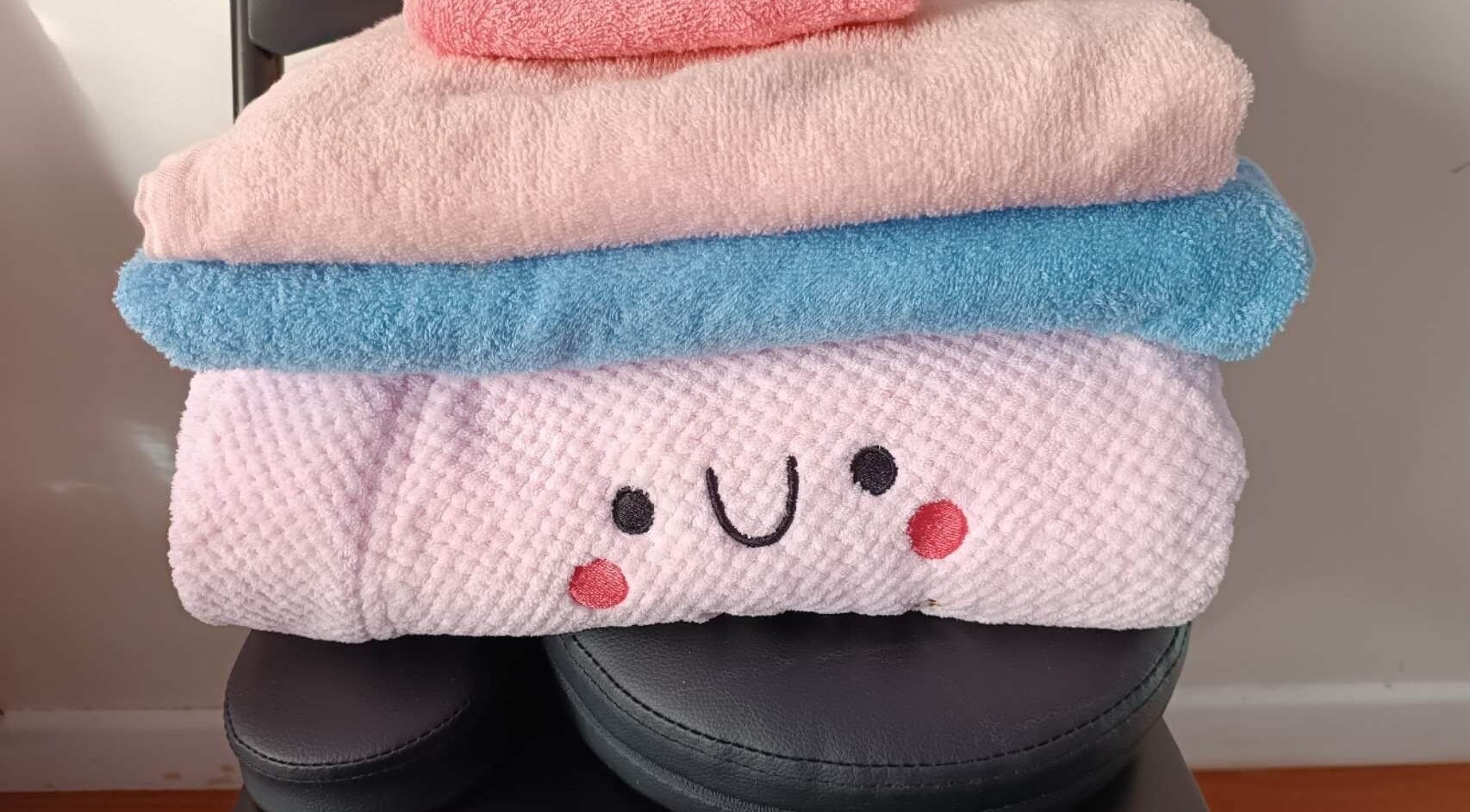 Stack of colorful towels at Harmony River - Home Studio (Sandringham), Auckland, NZ, creating a cozy vibe.