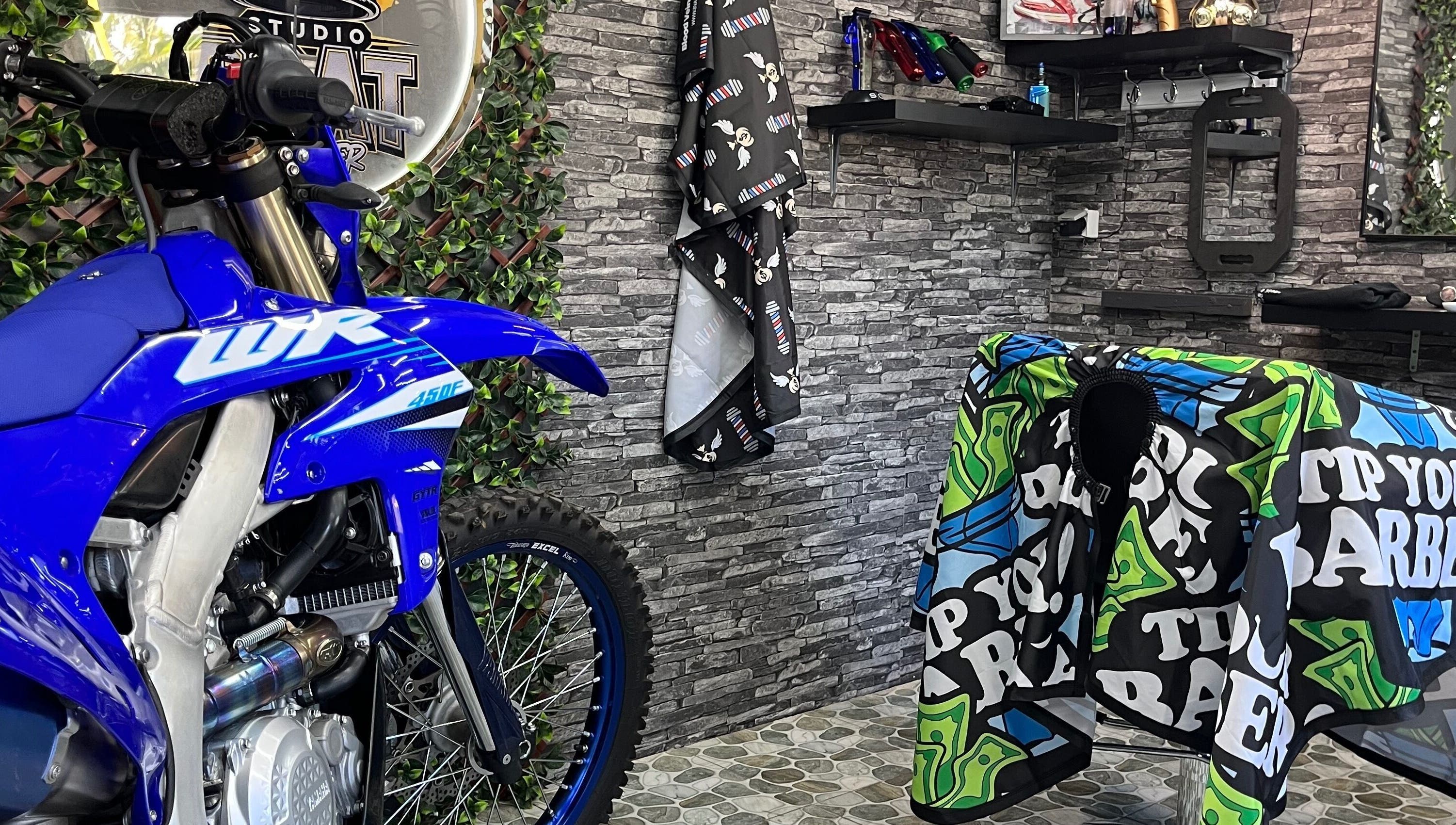 Studio goat barber à Papeete, Îles Du Vent, PF - intérieur unique avec moto décorative et chaise de coiffure.