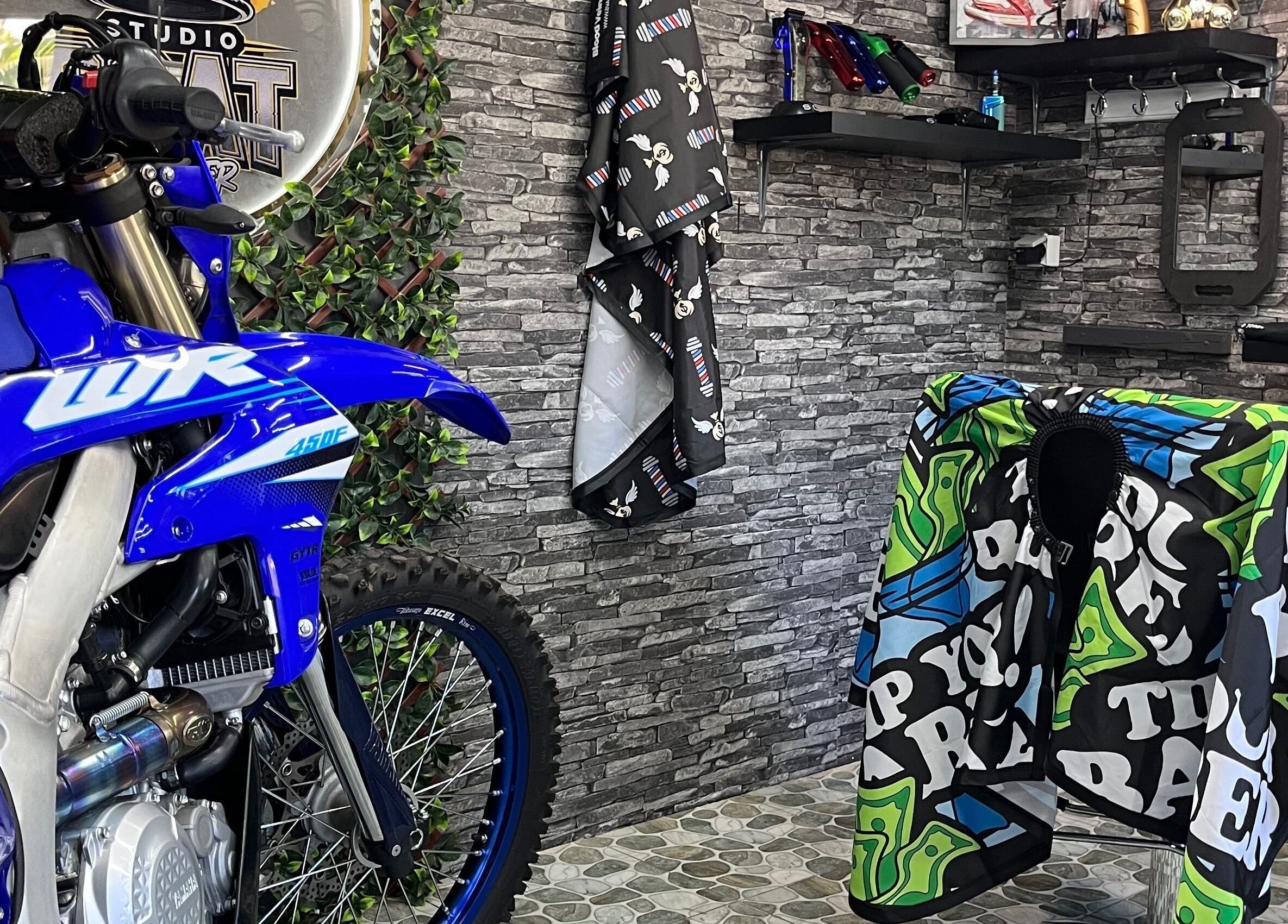 Intérieur branché de Studio goat barber à Papeete, Îles Du Vent, PF avec moto bleue décorative.