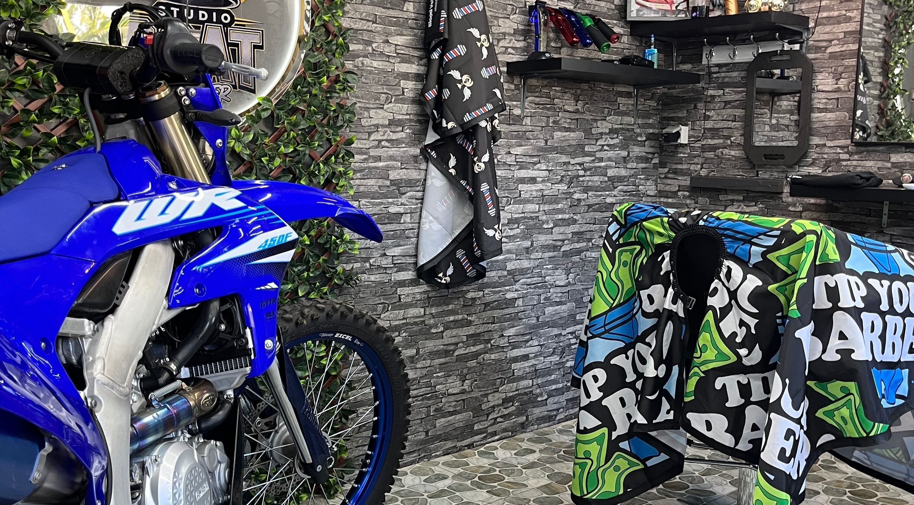 Intérieur branché de Studio goat barber à Papeete, Îles Du Vent, PF avec moto bleue décorative.