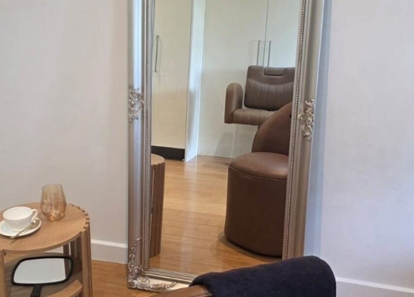Elegant mirror and seating area at Jocelyn Hair Xo, Melbourne, AU showcasing modern decor and comfort.