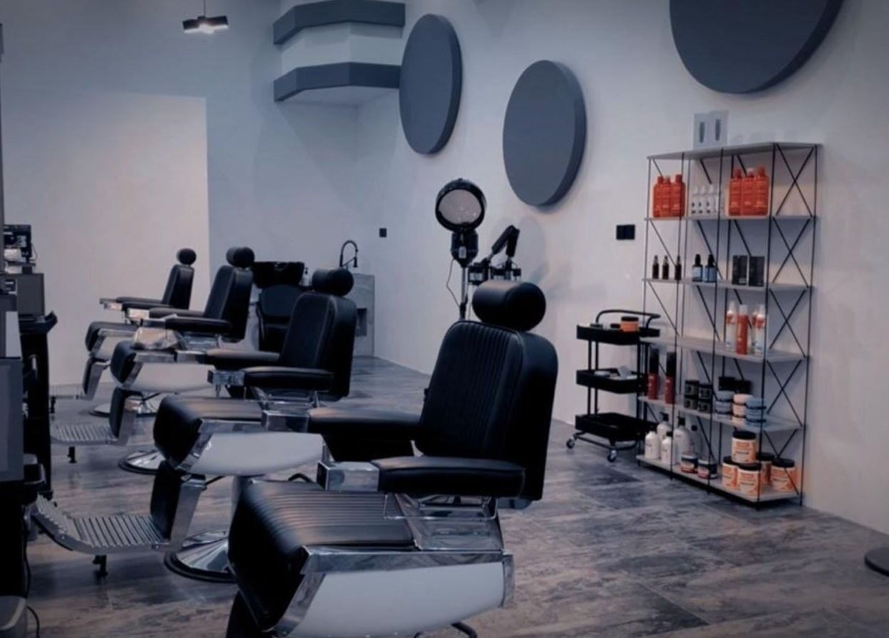 صالون حلاقة فاخر في 7CUT، الهفوف، الشرقية، السعودية يضم كراسي حديثة وأدوات تجميل.