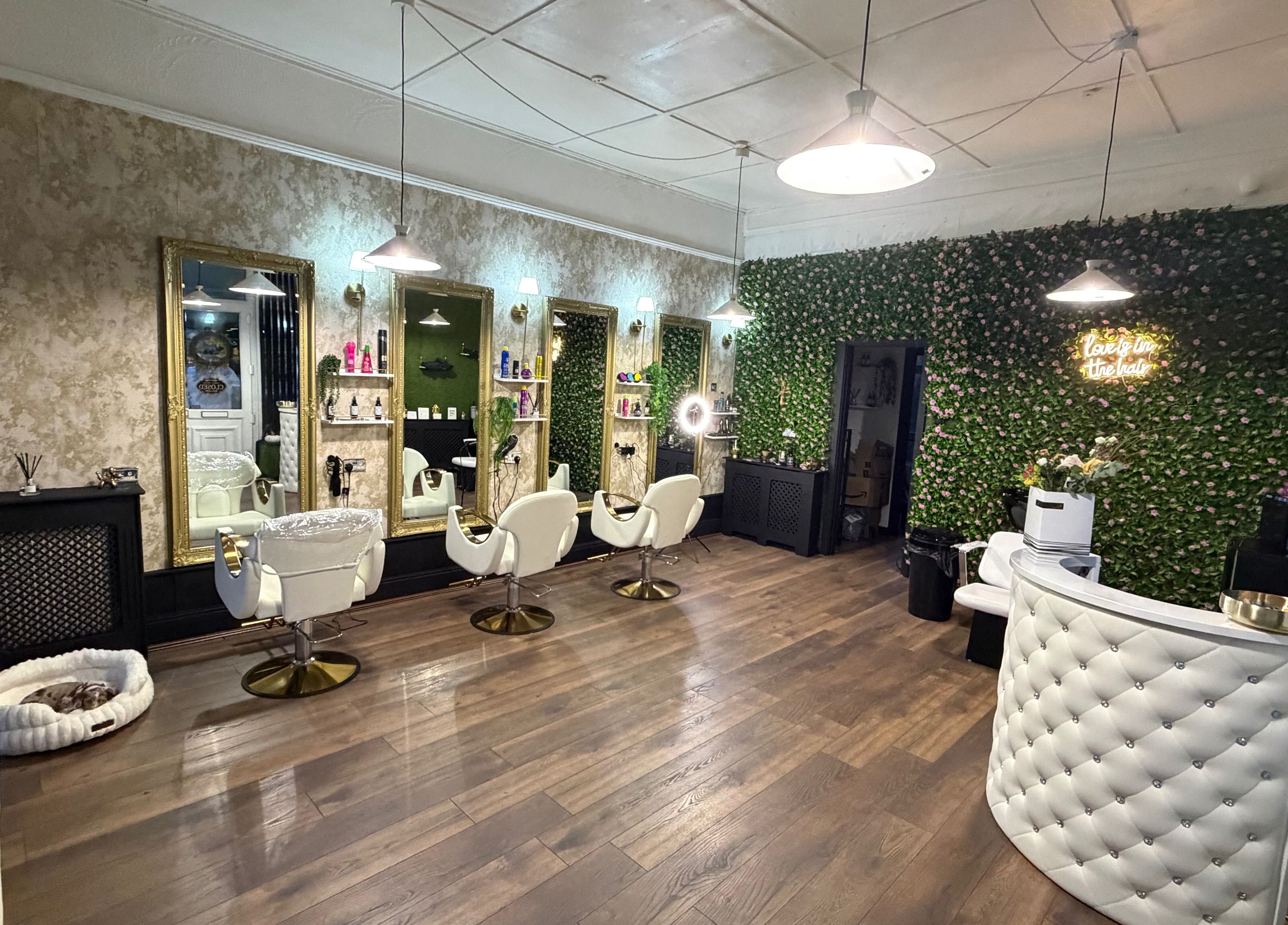 Stylish salon interior of 133 by el ltd in Dewsbury, England, GB with white chairs and green wall.