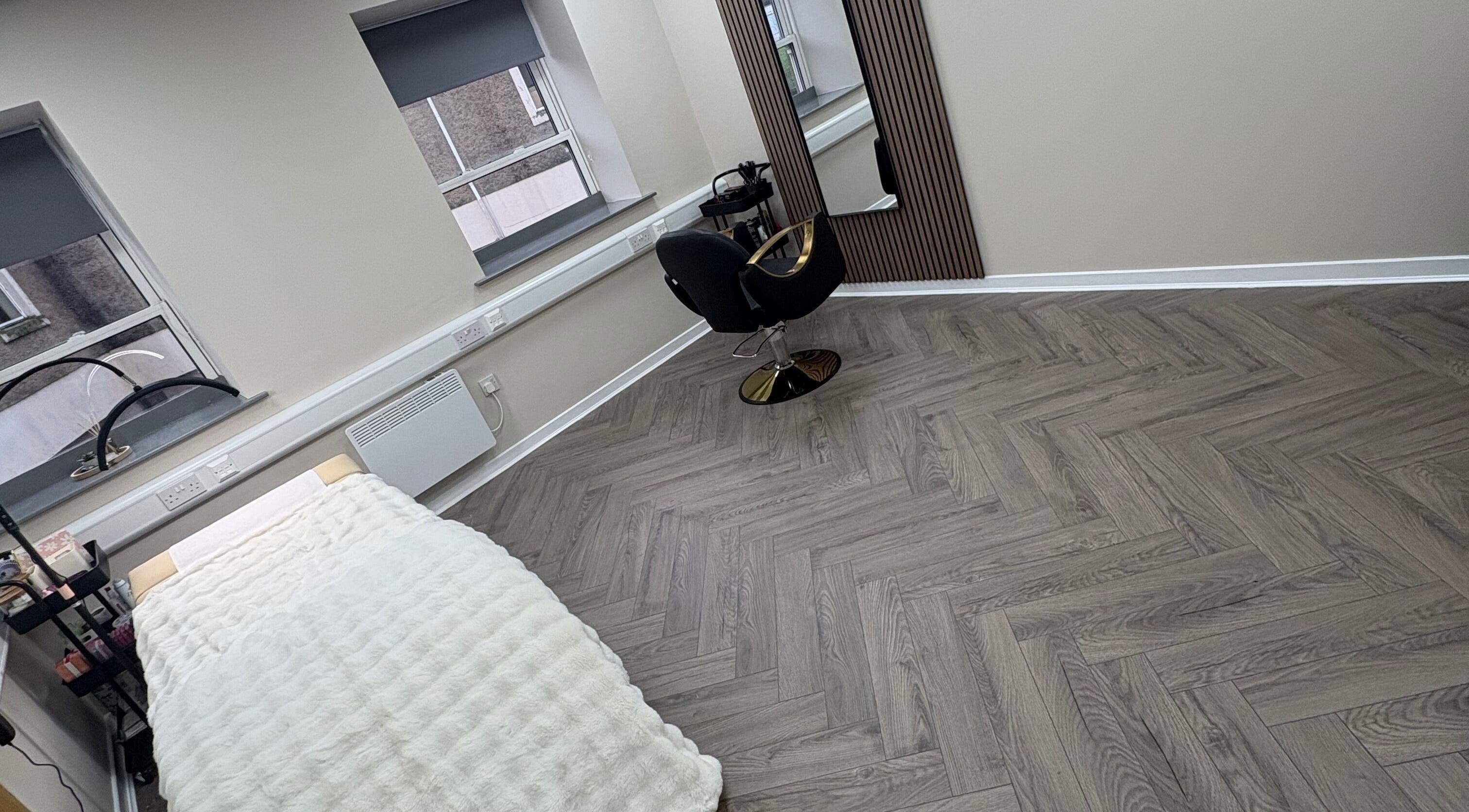 Modern beauty treatment room at Abuela in Kilmarnock, Scotland, GB with sleek decor and cozy bed.