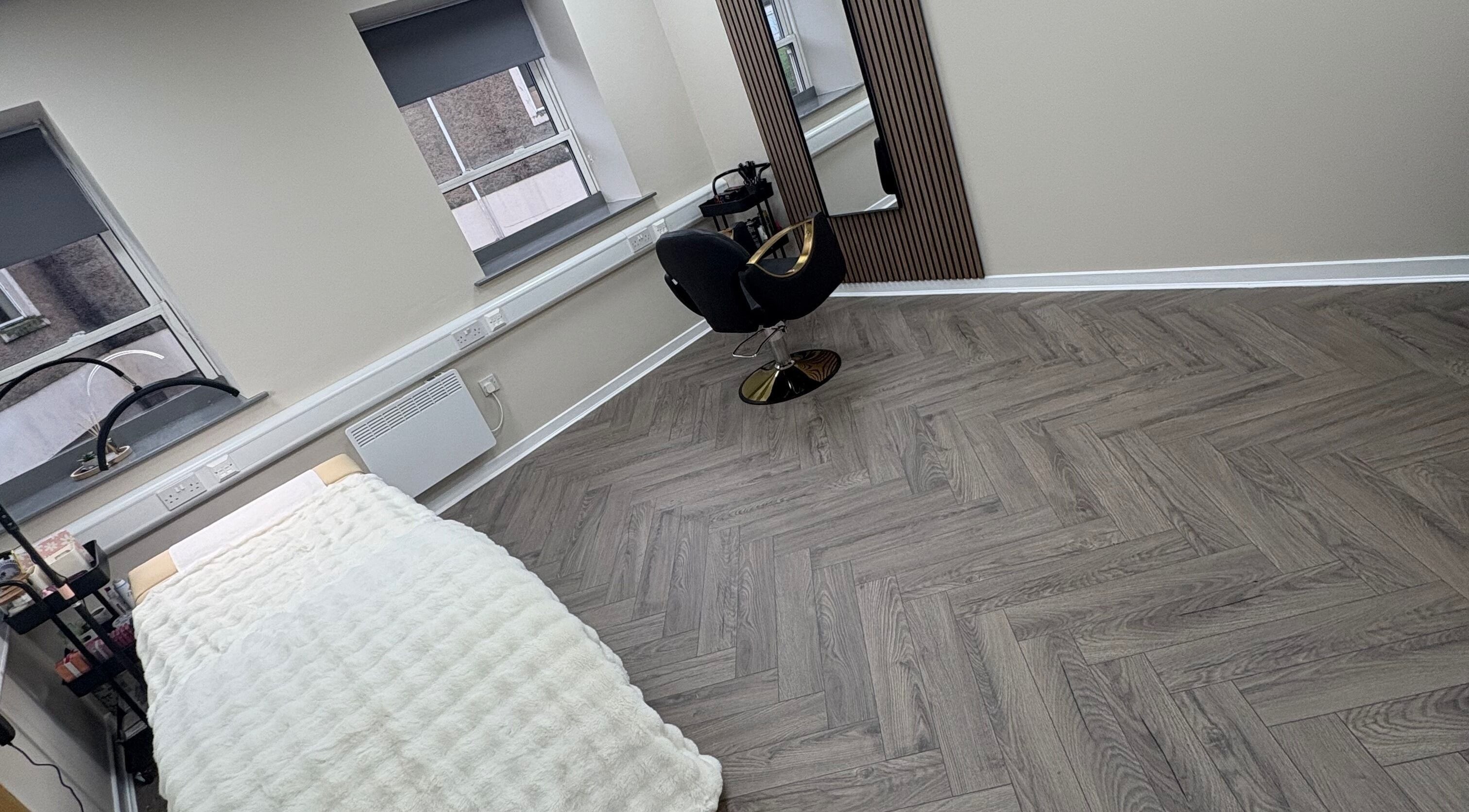 Modern beauty treatment room at Abuela in Kilmarnock, Scotland, GB with sleek decor and cozy bed.