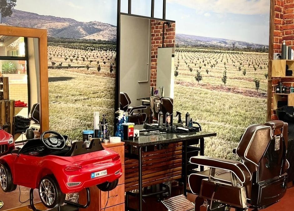 Buffelsfontein Barbier Menlo Park interior in Pretoria, Gauteng showcasing vintage barber chairs and brick walls.