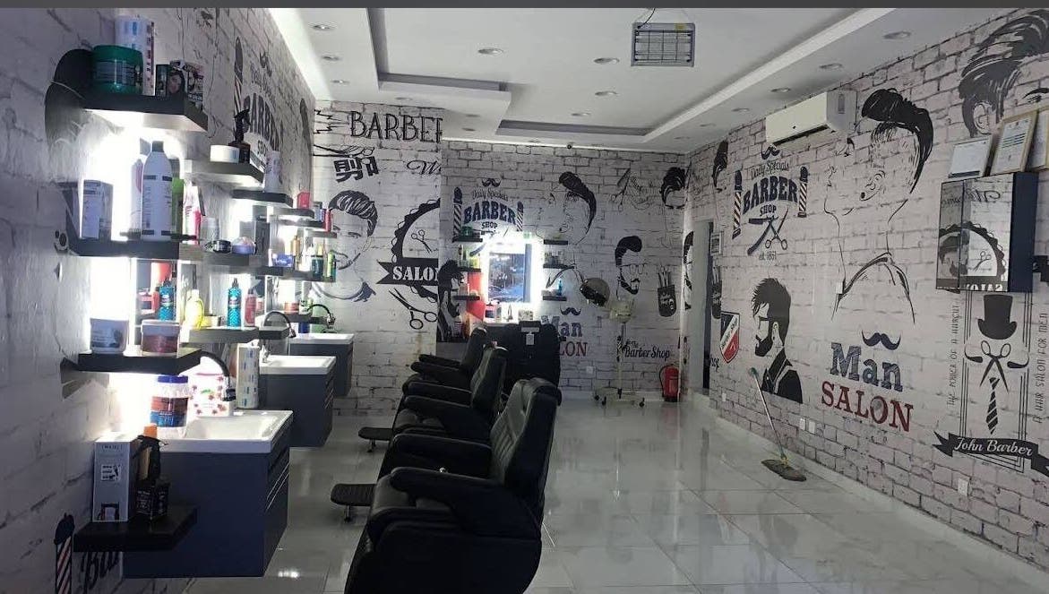 صالون حديث في نحتت الاطلس للحلاقة بالرياض, منطقة الرياض, SA مع مقاعد راقية وجدران مرسومة.