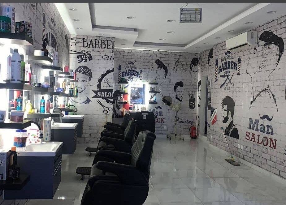 صالون حديث في نحتت الاطلس للحلاقة بالرياض, منطقة الرياض, SA مع مقاعد راقية وجدران مرسومة.