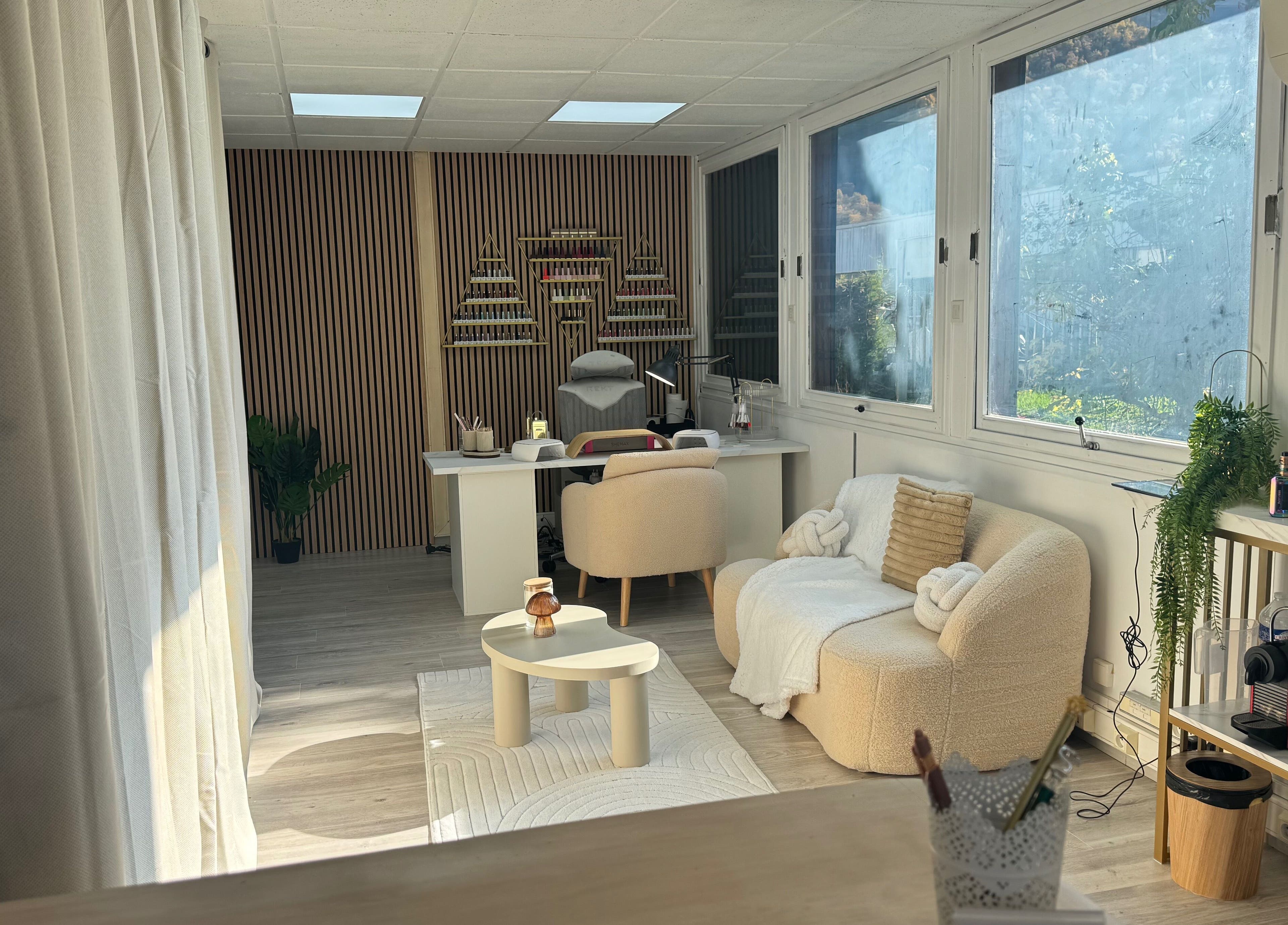 Intérieur chic de Happy Nail's à Domène, Auvergne-rhône-alpes, FR avec un canapé élégant et une table moderne.