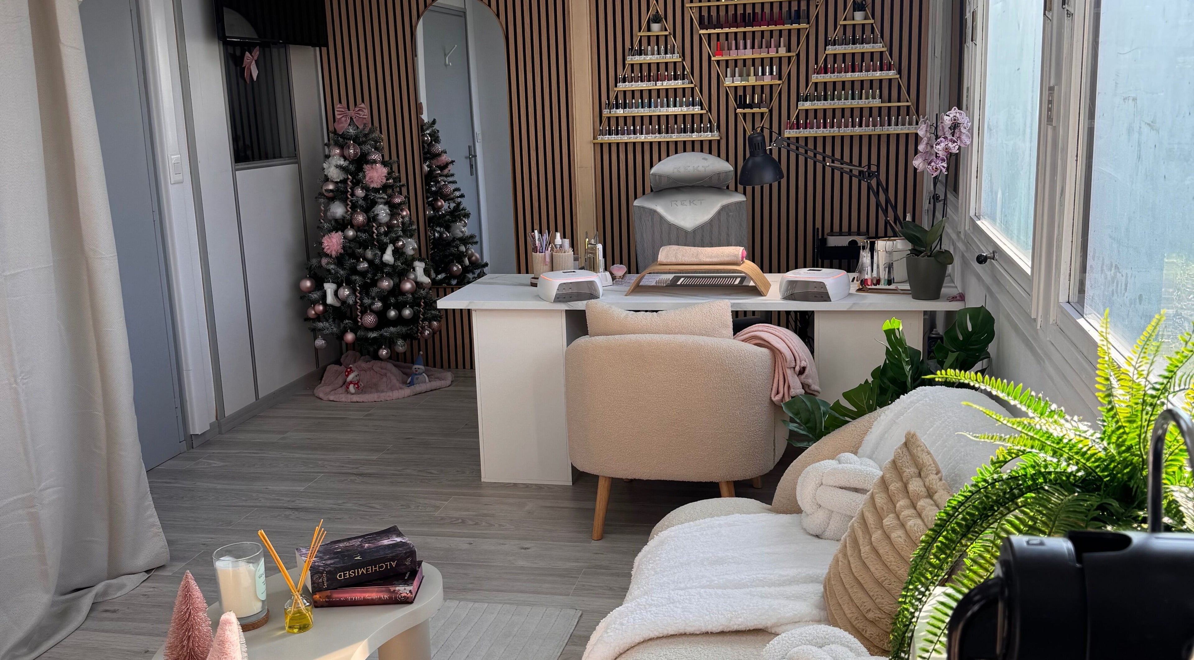 Salon élégant de Happy Nail’s à Domène, Auvergne-rhône-alpes, FR, décoré pour Noël avec un sapin et des chaises confortables.