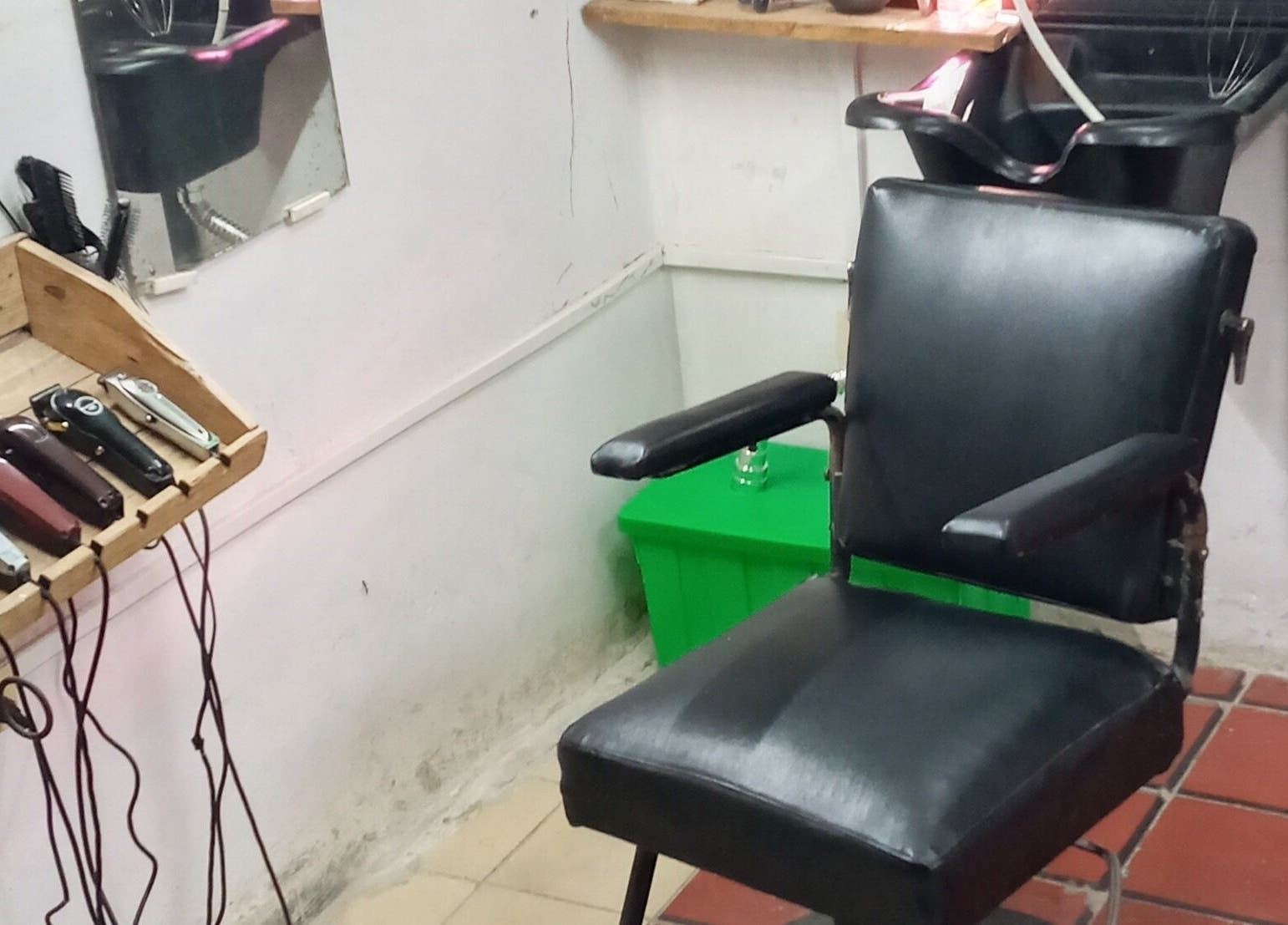 Sillón de barbero en Barbería Sion, La Habana, CU, con herramientas profesionales en estante.