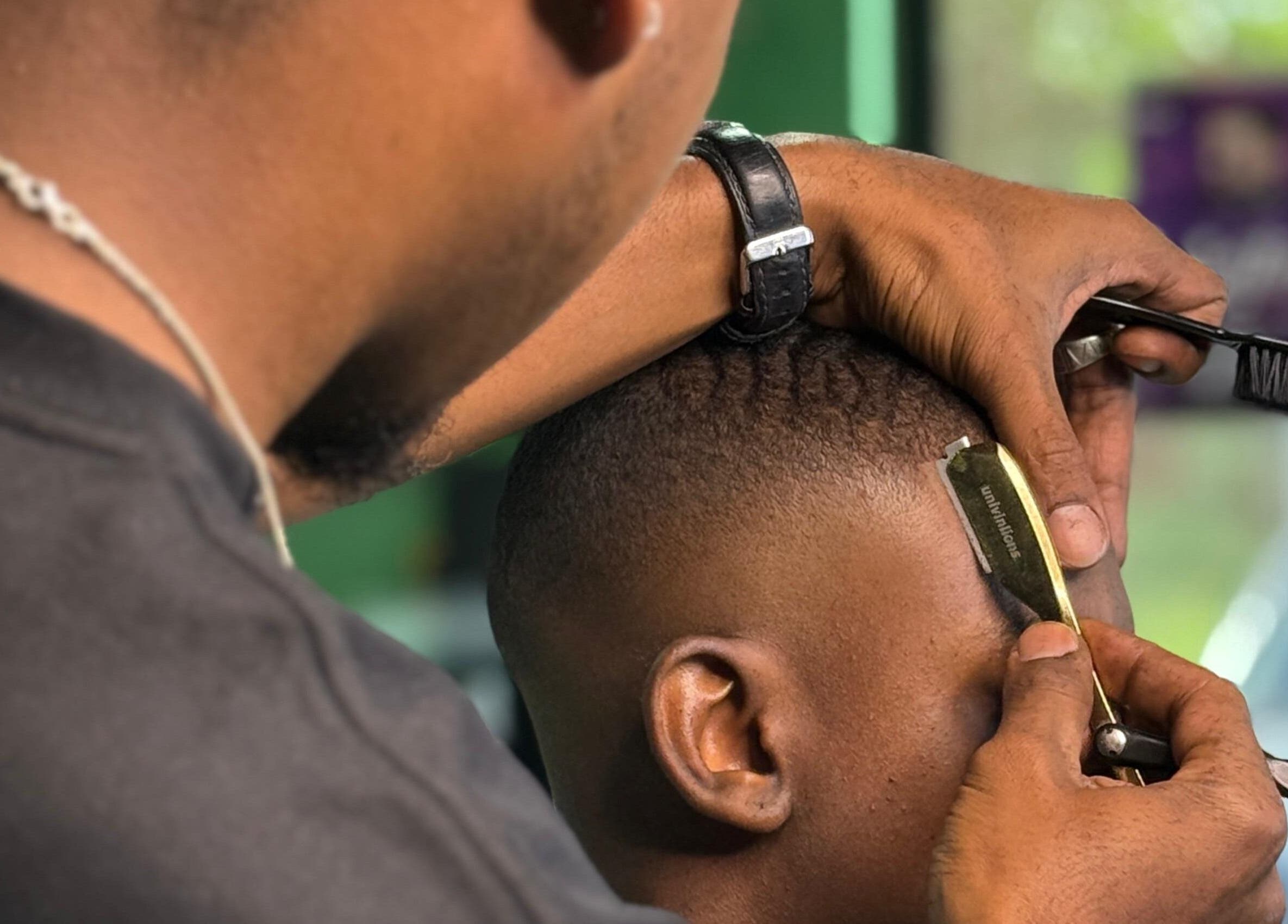 Expert barber styling hair at Het Hoofd Kantoor, Paramaribo, Paramaribo, SR with precision tools.