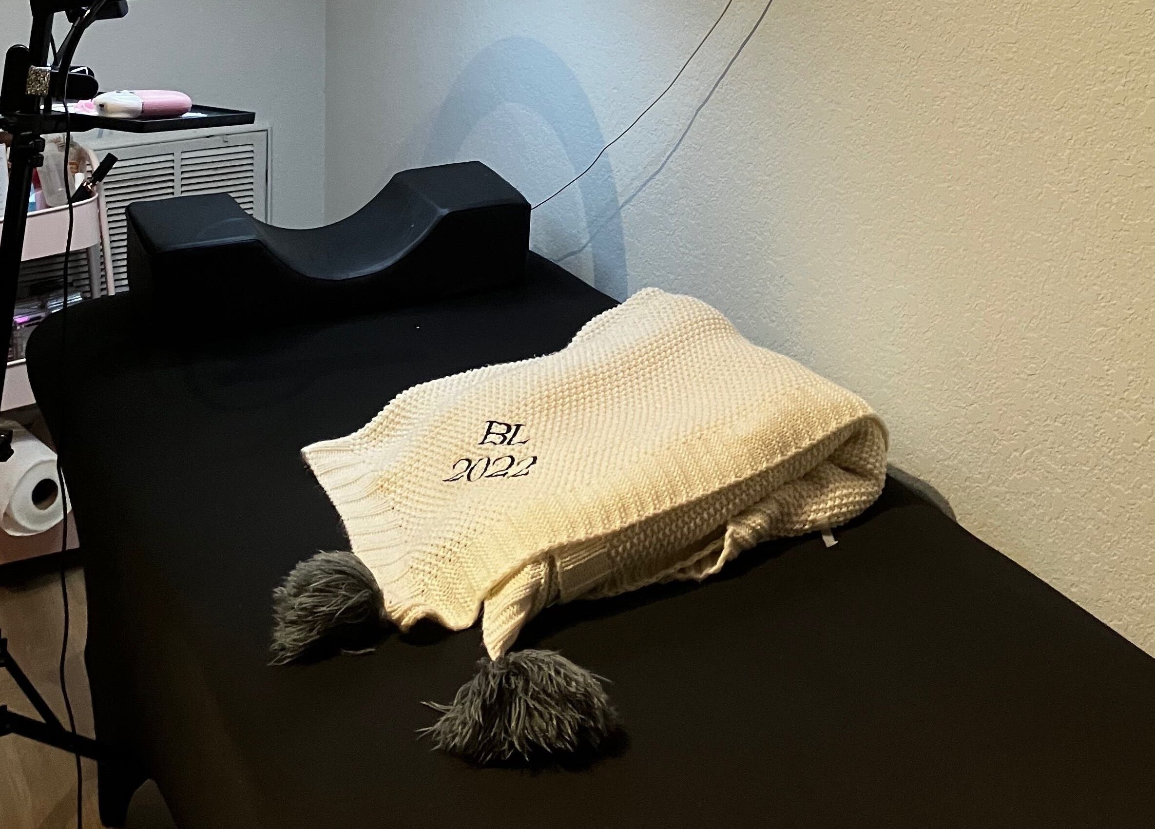 Comfortable treatment bed at B’LuxRoseLashesllc, Orlando, Florida, US, showcasing a warm, inviting atmosphere.