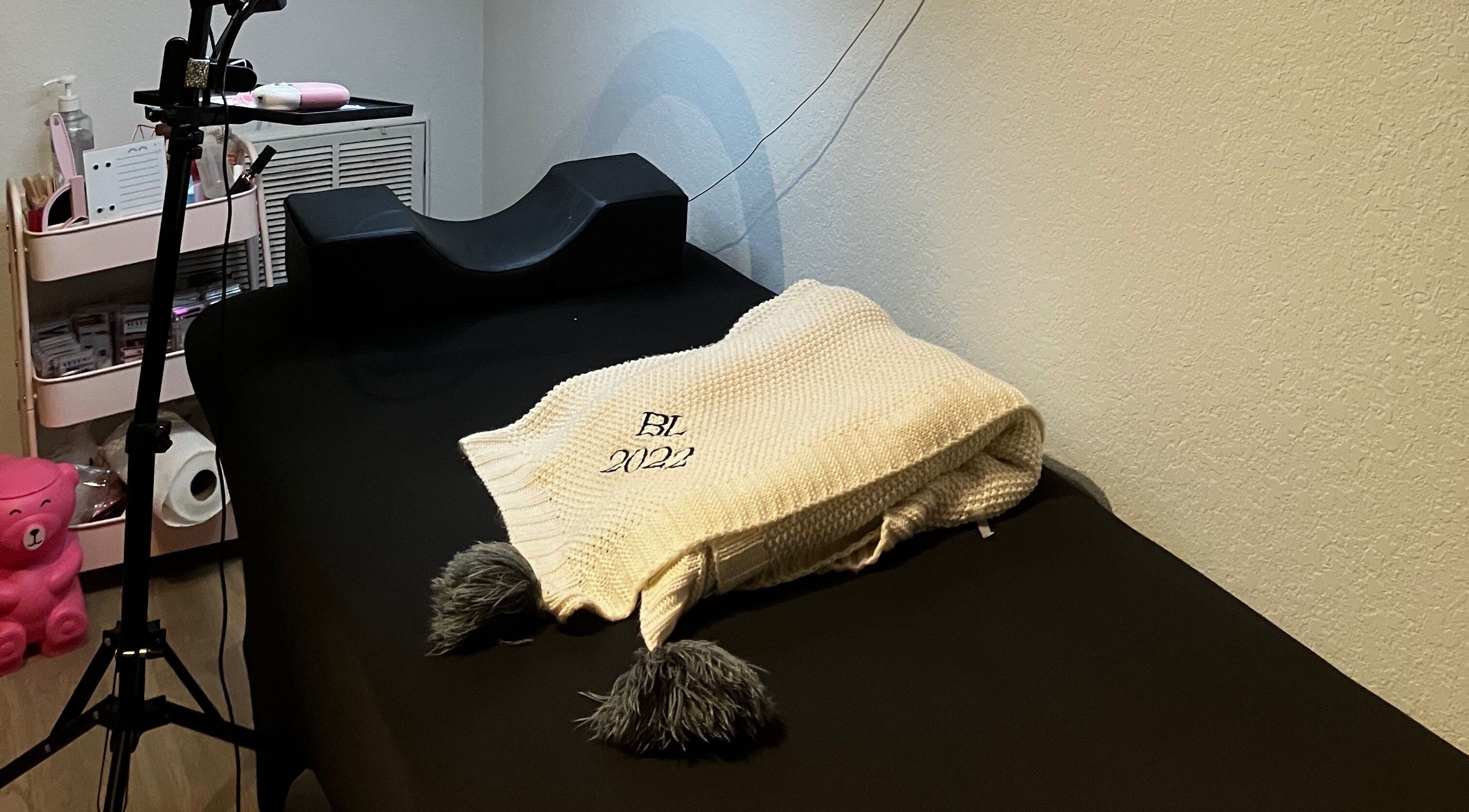 Comfortable treatment bed at B’LuxRoseLashesllc, Orlando, Florida, US, showcasing a warm, inviting atmosphere.