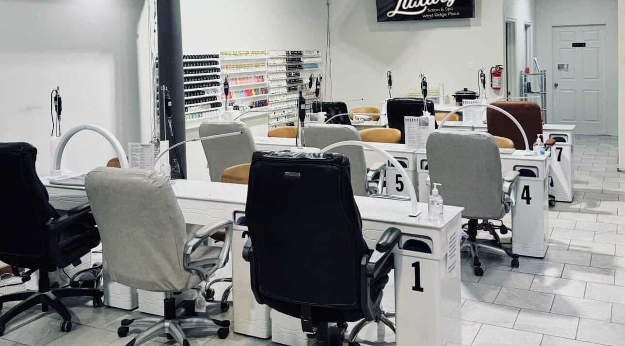 Nail station area inside Nail Luxury Salon & Spa Orillia, Orillia, Ontario, CA with multiple chairs and polish wall.